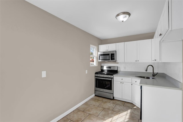 kitchen with light tile patterned floors, stainless steel appliances, sink, and white cabinets