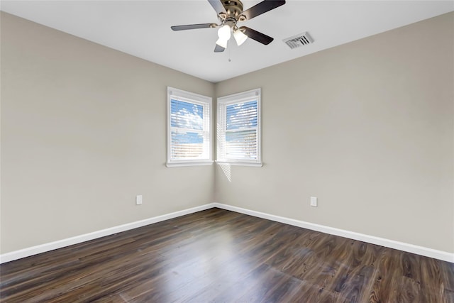 spare room featuring dark wood-type flooring and ceiling fan