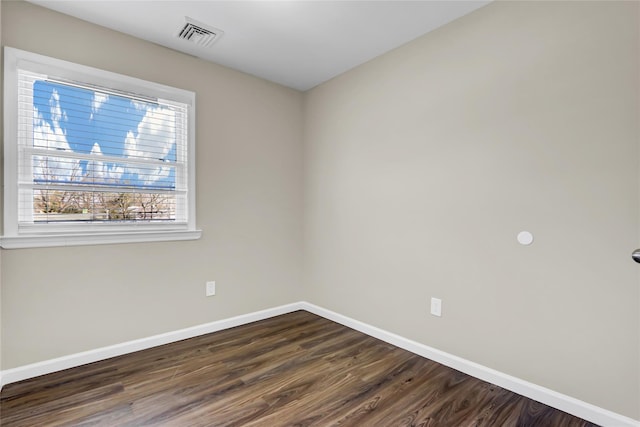 empty room with a healthy amount of sunlight and dark hardwood / wood-style floors