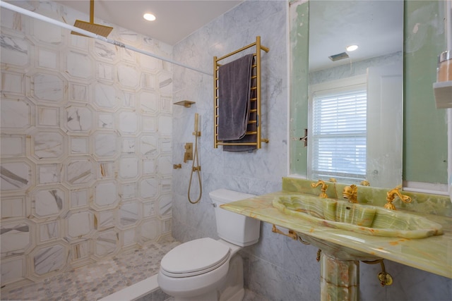 bathroom featuring tile walls, toilet, and tiled shower