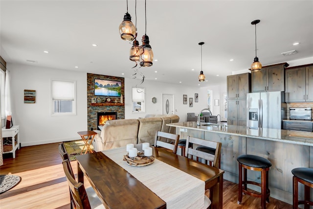 dining space featuring a fireplace and light hardwood / wood-style floors