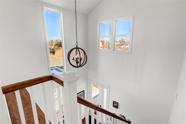 stairs with an inviting chandelier and plenty of natural light