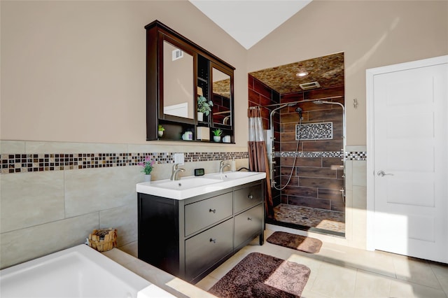 bathroom featuring tile walls, tile patterned flooring, vanity, curtained shower, and vaulted ceiling