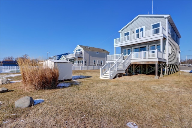 rear view of property with a yard and a balcony