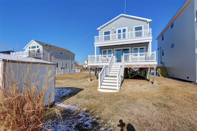 back of property featuring a balcony and a lawn