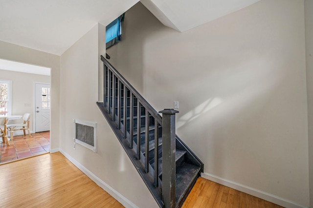 stairway with wood-type flooring and heating unit