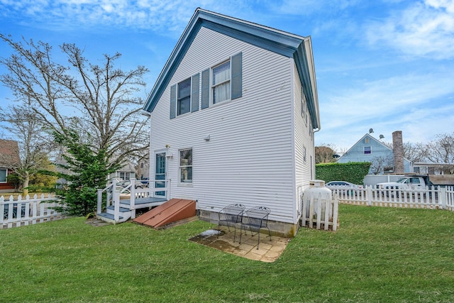 back of house featuring a deck and a lawn