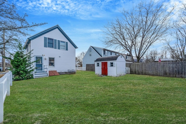 back of house with a storage shed and a yard