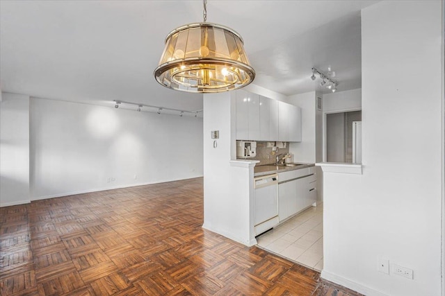 kitchen with dishwasher, sink, white cabinets, decorative backsplash, and a notable chandelier