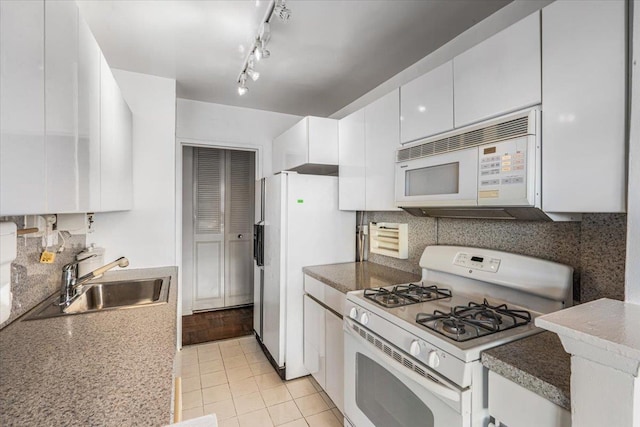 kitchen with sink, light tile patterned floors, white cabinets, white appliances, and backsplash