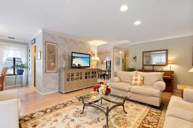 living room with ornamental molding and light wood-type flooring