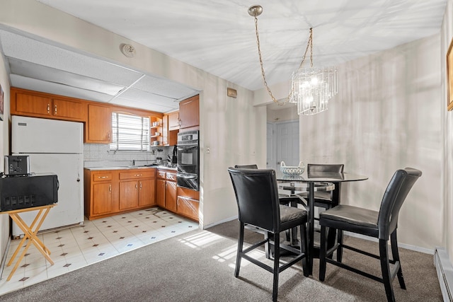 carpeted dining space featuring a baseboard heating unit, sink, and an inviting chandelier