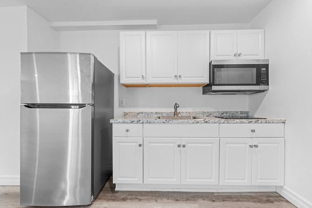 kitchen with stainless steel appliances, sink, and white cabinets