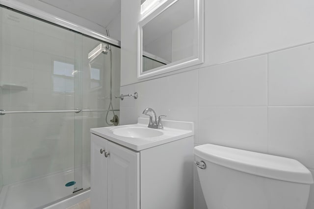 bathroom featuring a shower with shower door, tile walls, backsplash, vanity, and toilet