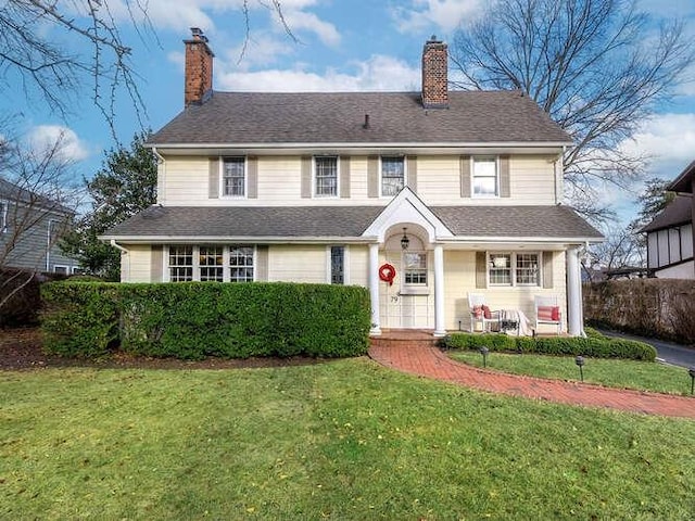 view of front of house with covered porch and a front yard