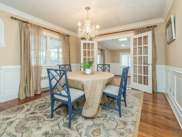 dining area with crown molding, dark wood-type flooring, and a chandelier