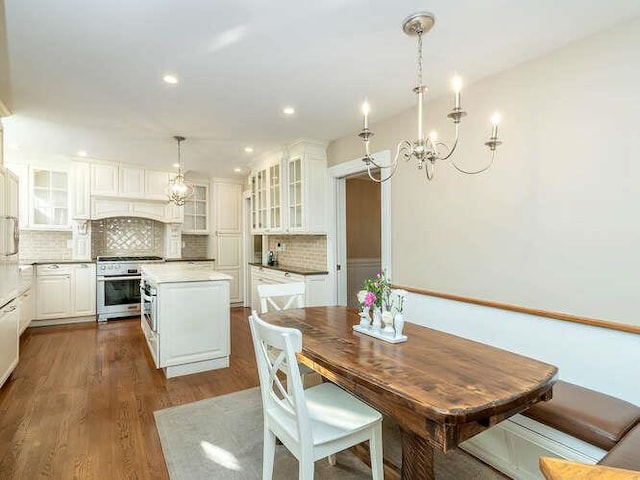 kitchen featuring white cabinets, decorative light fixtures, stainless steel range oven, and a kitchen island