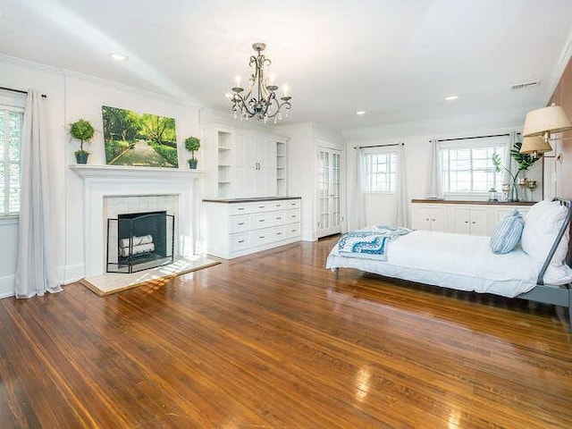 unfurnished bedroom with multiple windows, dark wood-type flooring, and a fireplace