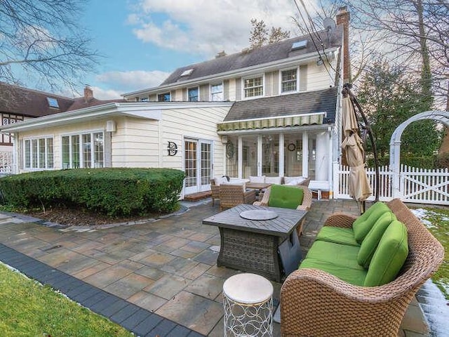 rear view of property with french doors, an outdoor living space, and a patio