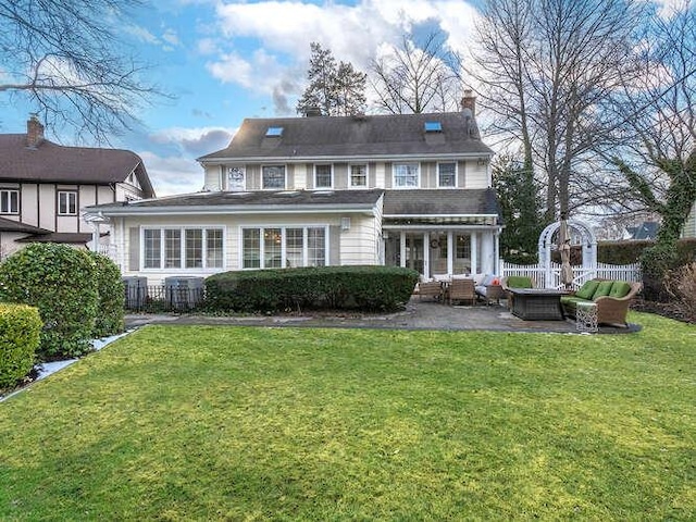 rear view of house with outdoor lounge area, a patio area, central air condition unit, and a lawn