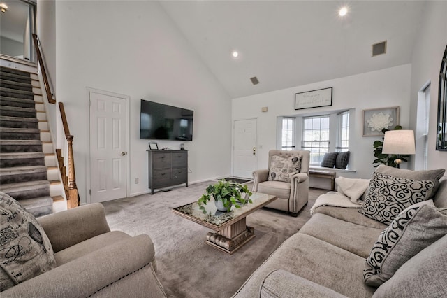 carpeted living room with high vaulted ceiling