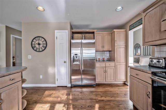 kitchen featuring tasteful backsplash, dark wood-type flooring, light brown cabinets, and appliances with stainless steel finishes