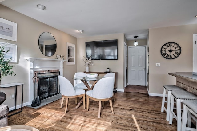 dining room featuring hardwood / wood-style floors and a fireplace