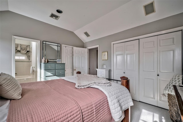 bedroom featuring multiple closets, connected bathroom, vaulted ceiling, and light carpet