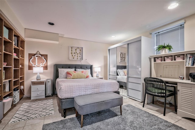 bedroom with light tile patterned flooring, built in desk, and a closet