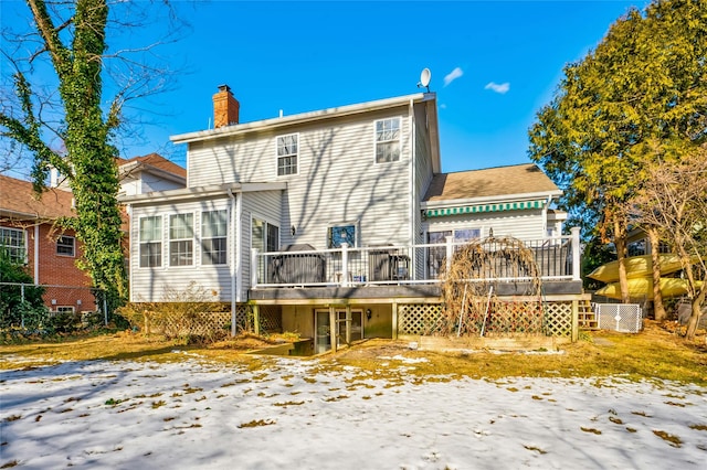 snow covered rear of property featuring a wooden deck