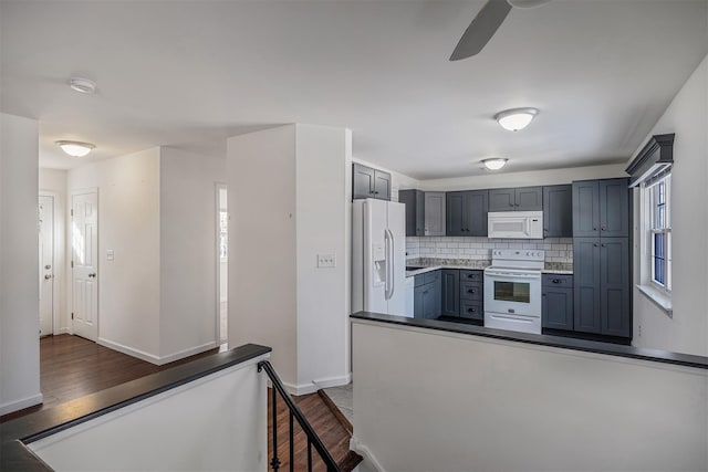 kitchen featuring white appliances, dark hardwood / wood-style floors, decorative backsplash, and gray cabinets