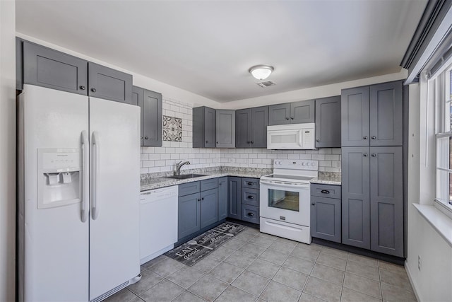 kitchen featuring white appliances, light tile patterned floors, sink, and backsplash