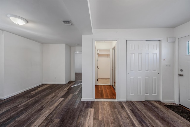 unfurnished bedroom with dark hardwood / wood-style floors and a closet