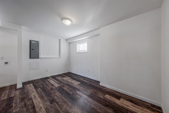 empty room with dark hardwood / wood-style floors and electric panel