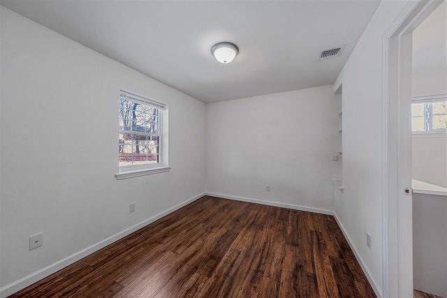 unfurnished room with dark wood-type flooring and a wealth of natural light