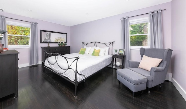 bedroom with dark wood-type flooring and multiple windows