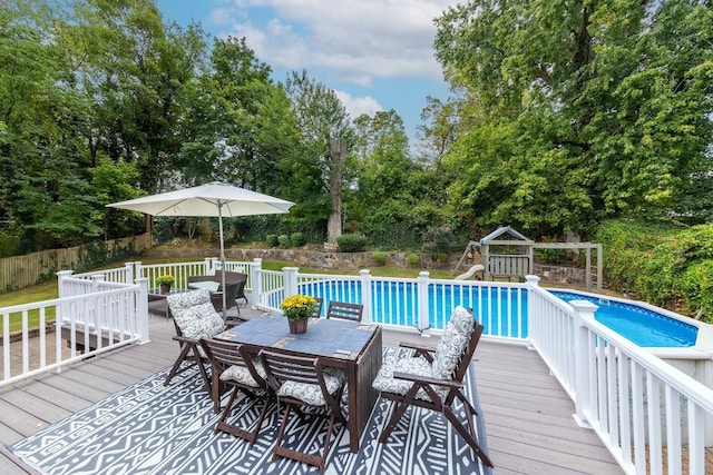 view of pool featuring a playground and a deck