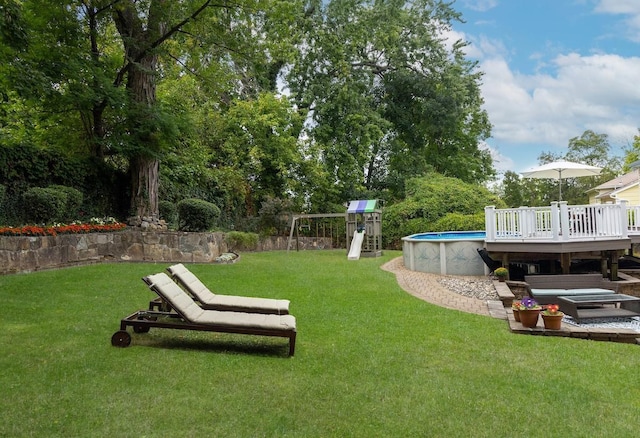 view of yard featuring a pool side deck and a playground