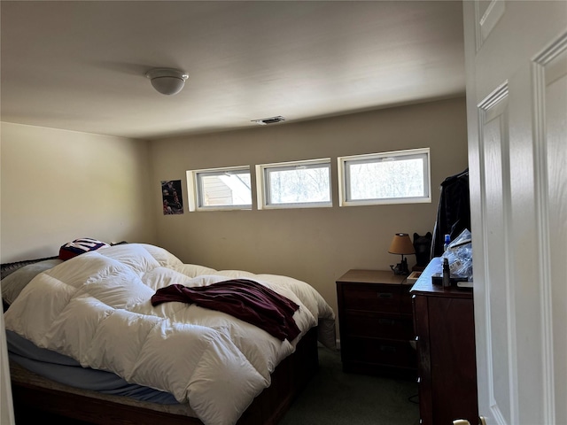 bedroom with visible vents, multiple windows, and dark carpet