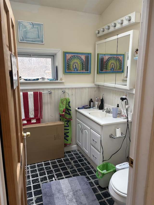 bathroom featuring tile patterned floors, a wainscoted wall, toilet, and vanity