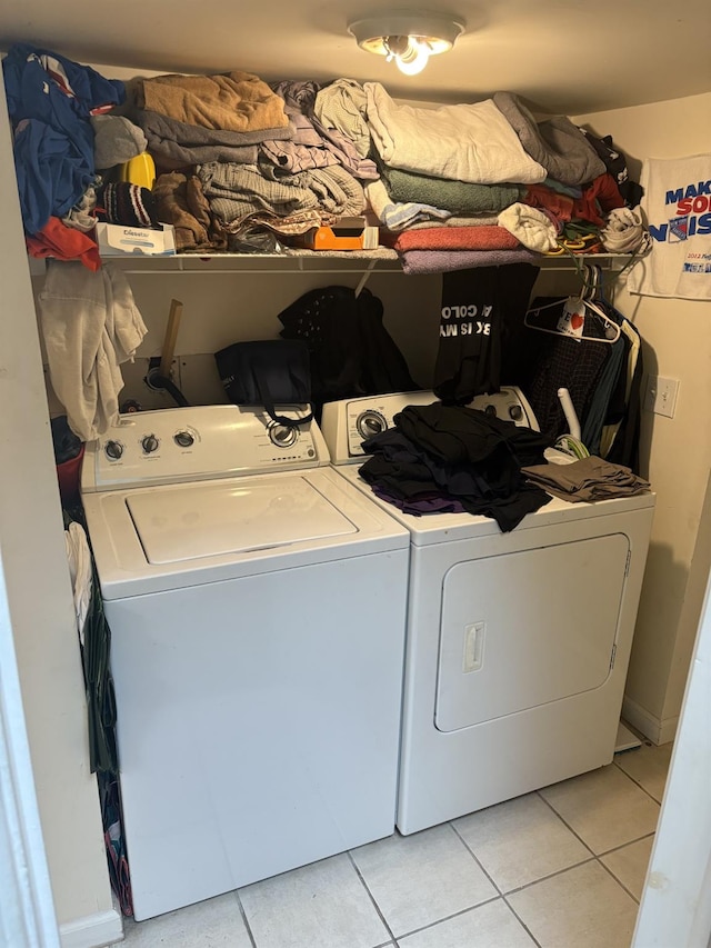 laundry room with light tile patterned floors and washer and clothes dryer