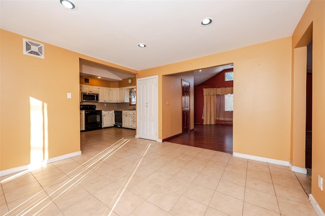 unfurnished living room with light tile patterned flooring and vaulted ceiling