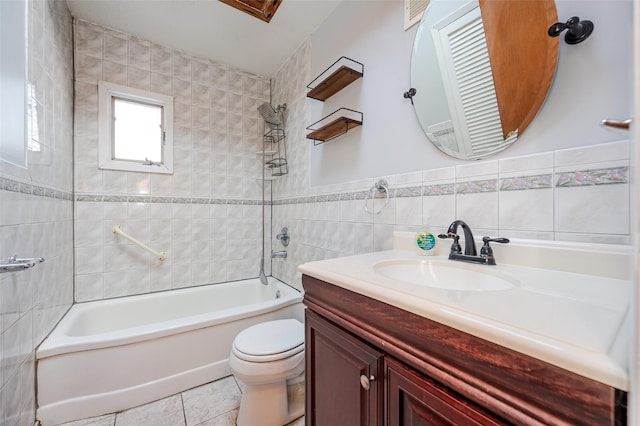 full bathroom with tile walls, tile patterned flooring, vanity, tiled shower / bath combo, and toilet