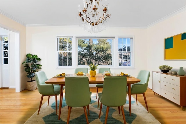 dining area featuring crown molding, a chandelier, and light hardwood / wood-style floors