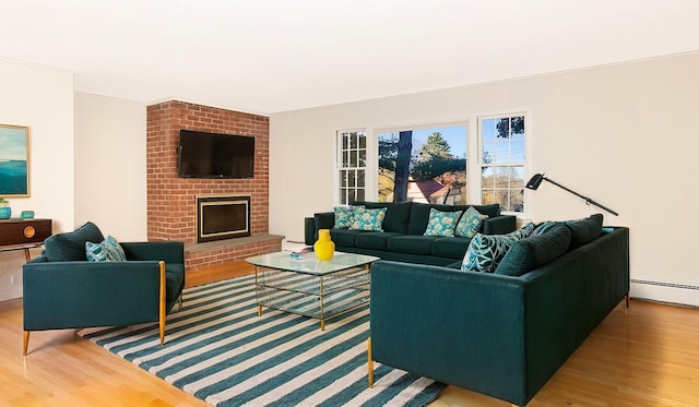 living room featuring hardwood / wood-style flooring, a fireplace, and baseboard heating