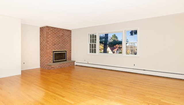 unfurnished living room with a brick fireplace, a baseboard heating unit, and light hardwood / wood-style floors