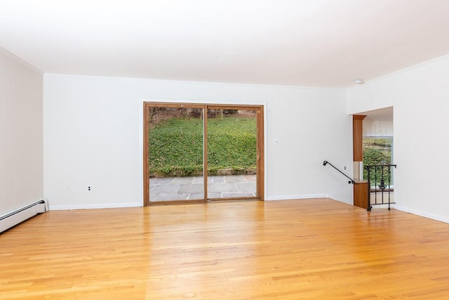 spare room with a baseboard heating unit, light hardwood / wood-style flooring, and ornamental molding