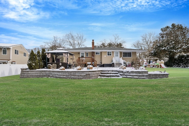 back of property with a yard, a gazebo, and a playground