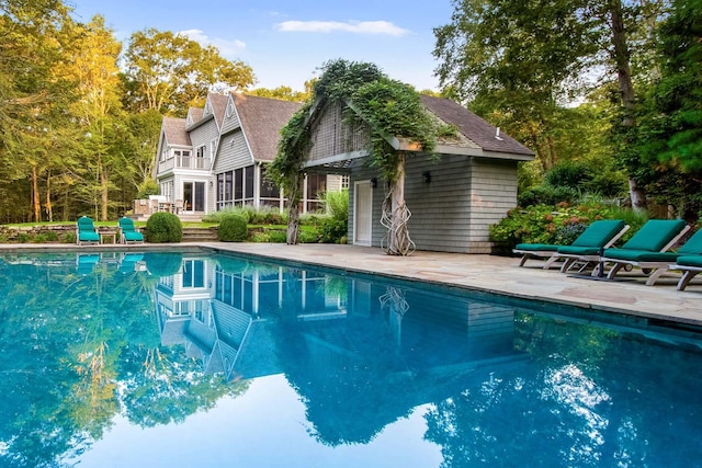 view of pool featuring a sunroom and a patio area