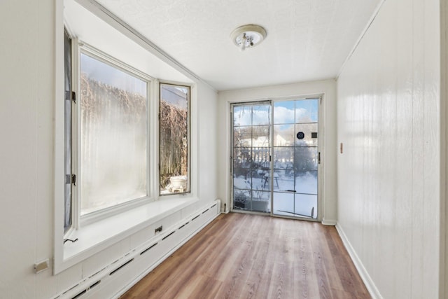 interior space featuring baseboard heating and light hardwood / wood-style flooring